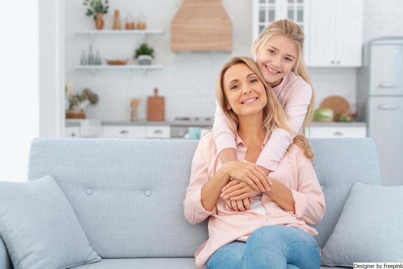 mãe com a filha sorrindo simbolizando a importância da autoestima.