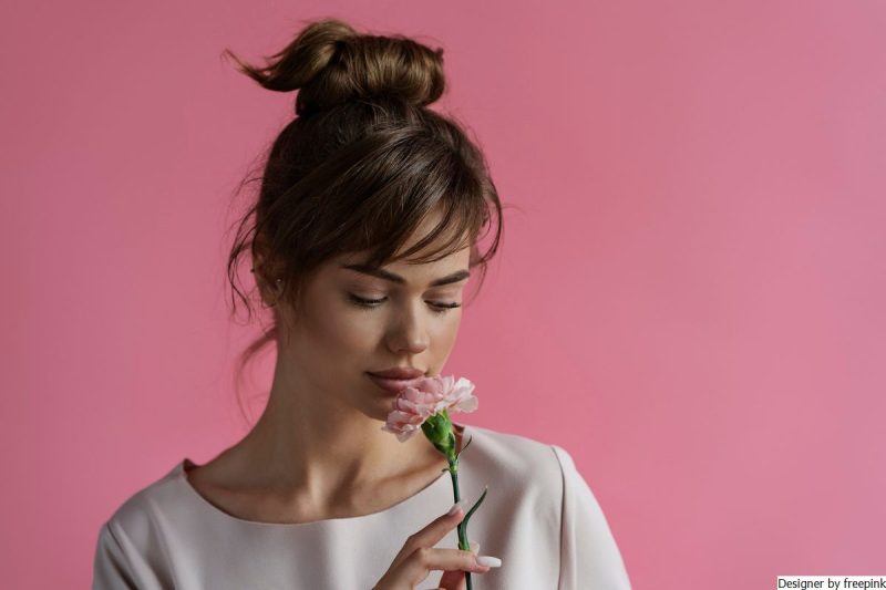 mulher jovem cheirando flor, representando a resistência à mudança.