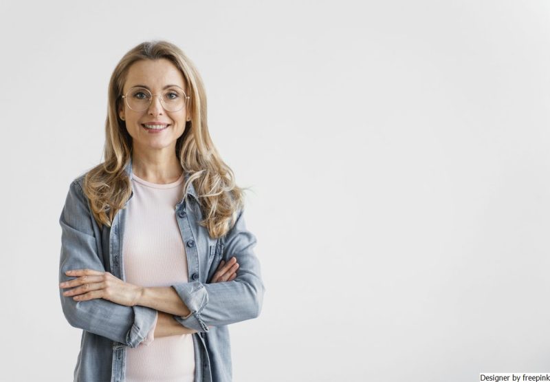 mulher loira, usa blusão jeans e camiseta branca. Usa óculos de grau simbolizando a Terapia de Aceitação e compromisso.