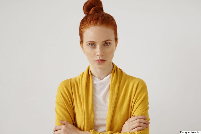 mulher branca, jovem, ruiva, veste blusa branca e amarela de mangas compridas representa como parar de se criticar.